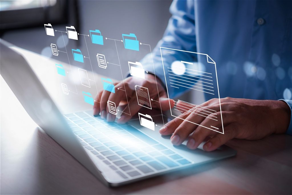 Manos sobre laptop con archivos digitales